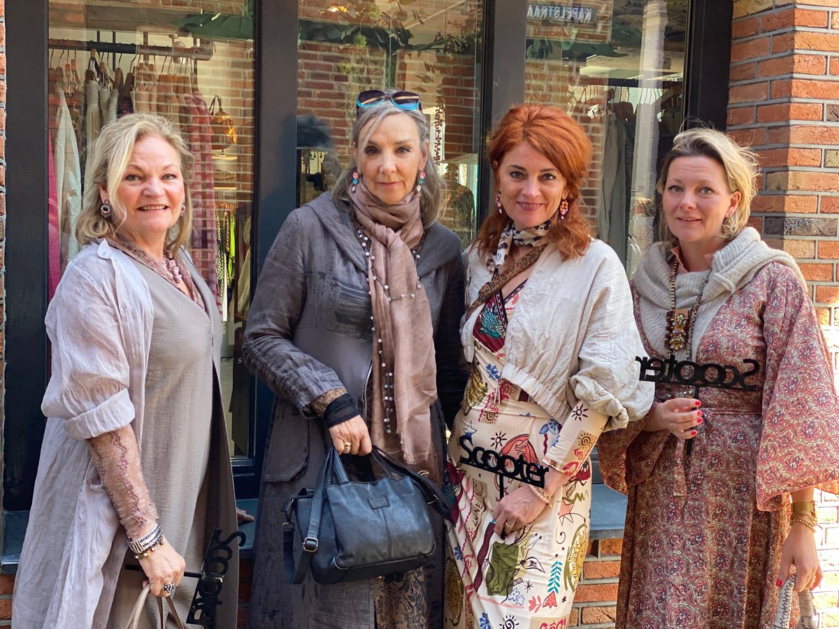 Vier dames van Scooter voor de etalage